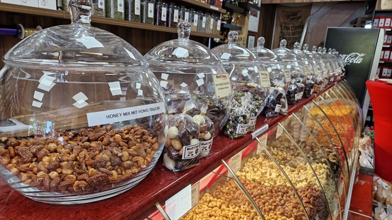 Große Glasbehälter auf einer Theke mit Nüssen gefüllt.