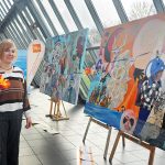 Künstlerin Godana Karawanke vor den Gemälden