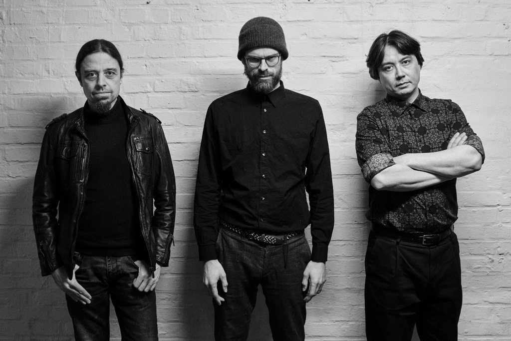 Bandfoto Hard Suit Love, drei Personen vor einer weißen Wand