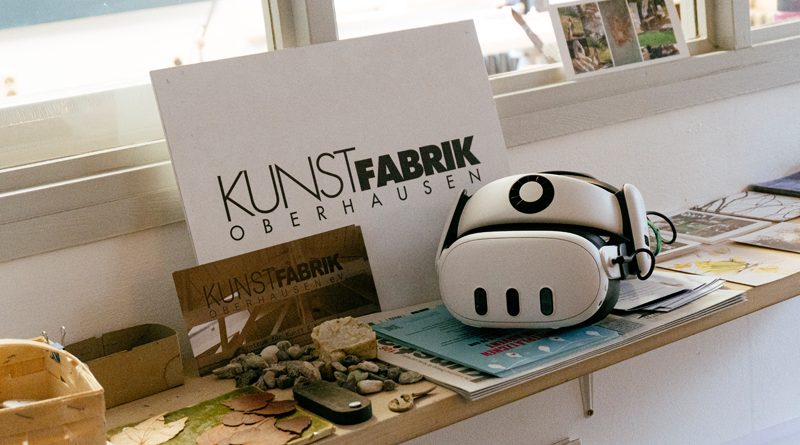 Eine Fensterbank auf der eine VR-Brille mit Büchern und einer Karte mit der Aufschrift Kunstfabrik zu sehen ist
