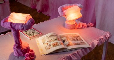 Kunstinstallation mit Tisch, Lampen und Literatur