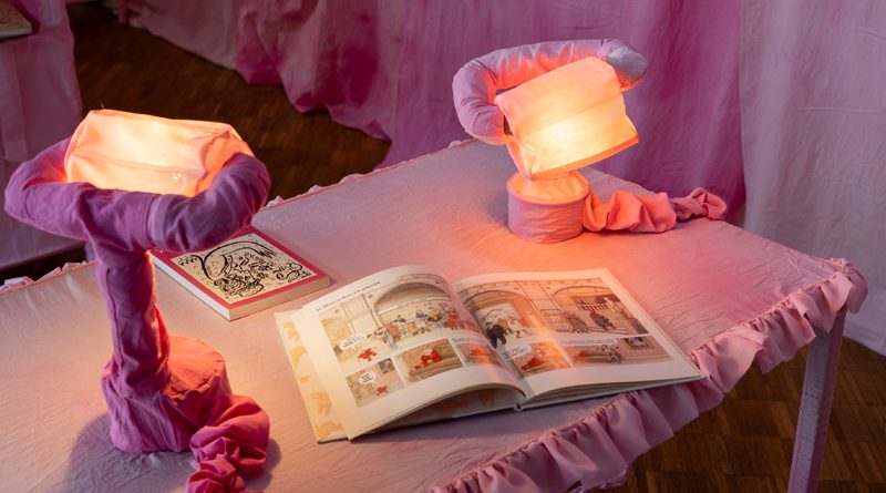 Kunstinstallation mit Tisch, Lampen und Literatur