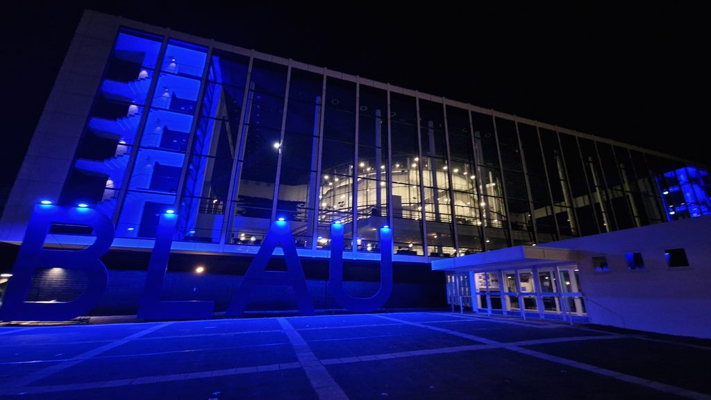 Musiktheaterfassade bei Nacht mit blauer Beleuchtung