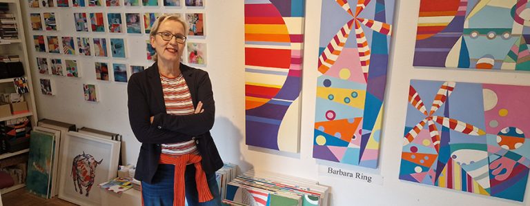 Barbara Ring vor ihren bunten Kunstwerken