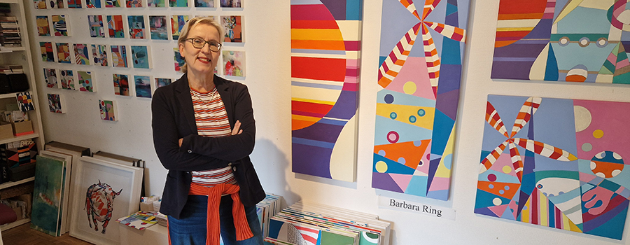 Barbara Ring vor ihren bunten Kunstwerken