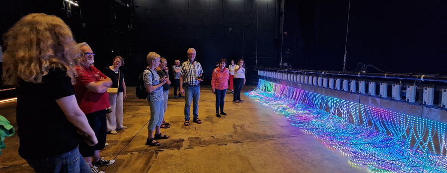 Publikum, das vor einem bunten LED Vorhang steht